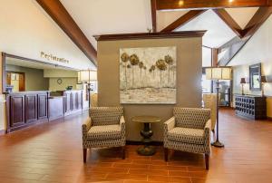 een lobby met 2 stoelen en een tafel en een schilderij bij Clarion Inn Harpers Ferry-Charles Town in Harpers Ferry