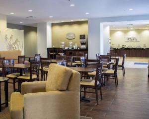 a restaurant with tables and chairs and a bar at Sleep Inn & Suites Moundsville in Moundsville