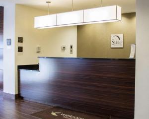 un vestíbulo con un mostrador de madera en un edificio en Sleep Inn & Suites Moundsville, en Moundsville