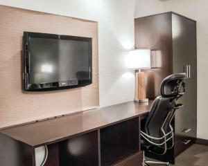 a hotel room with a desk with a chair and a tv at Sleep Inn in Summersville