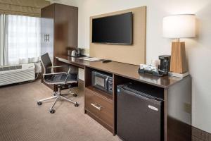 a hotel room with a desk with a tv and a chair at Sleep Inn in Charleston