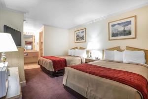 a hotel room with two beds and a television at Rodeway Inn Pronghorn Lodge in Lander