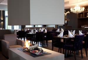 jadalnia ze stołami i krzesłami oraz kominkiem w obiekcie Fletcher Hotel-Restaurant Duinzicht w mieście Ouddorp