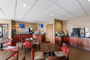 a restaurant with wooden tables and chairs and a counter at Comfort Inn & Suites Near University of Wyoming in Laramie