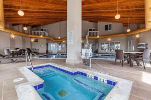 una piscina en medio de un edificio con mesas y sillas en Comfort Inn & Suites Near University of Wyoming, en Laramie