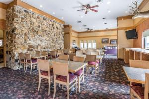 a dining room with tables and chairs and a stone wall at Quality Inn in Rock Springs +15 photos