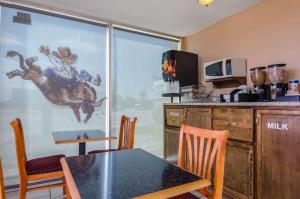 a dining room with a table and chairs and a window at Executive Inn Dodge City, KS in Dodge City