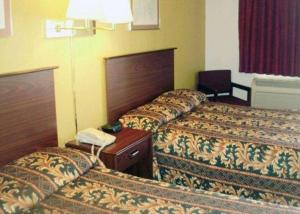 a hotel room with two beds and a phone at Rodeway Inn in Goddard