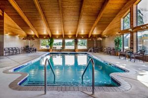 an indoor pool with a wooden ceiling and a large pool at Rodeway Inn in Hesston