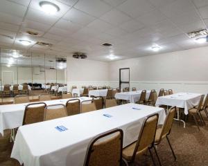 エンポリアにあるKnights Inn & Suites Emporiaのテーブルと椅子(白いテーブルクロス付)が備わる客室です。