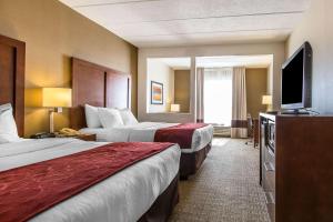 a hotel room with two beds and a flat screen tv at Comfort Suites Richmond in Richmond