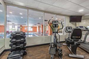 a gym with two exercise bikes and a swimming pool at Comfort Suites Richmond in Richmond