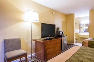 a hotel room with a television and a chair at AmeriVu Inn-Gilbertsville in Gilbertsville