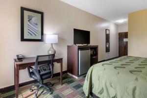 a hotel room with a bed and a desk and a chair at Quality Inn in Cadiz