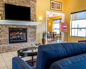 a living room with a blue couch and a fireplace at Comfort Inn & Suites Franklin East in Franklin