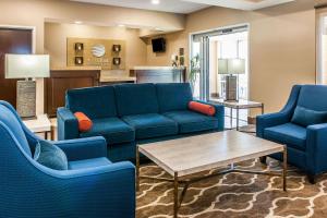 a living room with blue couches and a table at Comfort Inn & Suites Mount Sterling in Mount Sterling