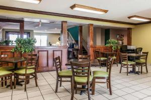 a restaurant with wooden tables and green chairs at Quality Inn Lewisport in Lewisport
