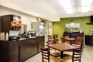Sleep Inn & Suites Metairie في ميتايري: مطعم بطاولة وكراسي ومطبخ
