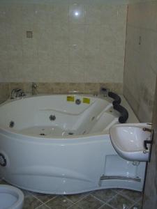 a bathroom with a tub and a toilet and a sink at Hadjibulevata Guest House in Kovachevtsi