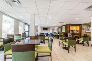 Comfort Inn & Suites في ليكسينغتون: غرفة طعام مع طاولات وكراسي في كافتيريا