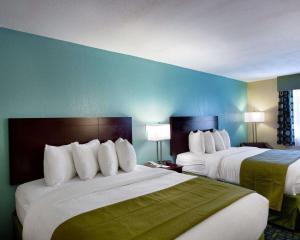Habitación de hotel con 2 camas y pared azul en Quality Inn Hammond, en Hammond