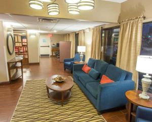 a living room with a blue couch and a table at Comfort Inn Hammond in Hammond