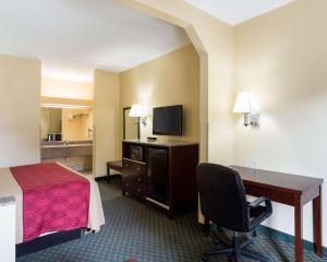 a hotel room with a bed and a desk with a computer at Rodeway Inn & Suites New Orleans Gentilly in New Orleans