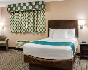 a hotel room with a large bed and a chair at Suburban Studios Avondale in Avondale