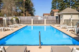 a swimming pool with chairs and a fence at Quality Inn Ruston in Ruston