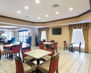 a restaurant with tables and chairs and a flat screen tv at Comfort Inn Marrero - New Orleans West in Marrero