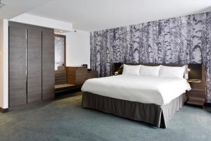 オタワにあるDoubleTree by Hilton Ottawa Downtownの白い大型ベッドと壁が備わるベッドルーム1室が備わります。 +37枚の写真
