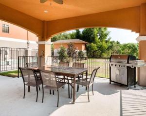 a patio with a table and chairs and a grill at Comfort Suites Oil Center in Lafayette