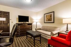 a living room with a couch and a tv at Evangeline Downs Hotel, Ascend Hotel Collection in Opelousas