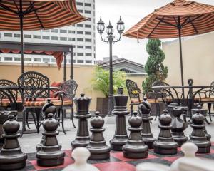 a chess board on a patio with tables and umbrellas at Bluegreen Vacations Club La Pension in New Orleans