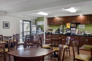 a restaurant with tables and chairs and a kitchen at Sleep Inn Baton Rouge East I-12 in Baton Rouge