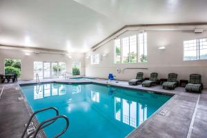 une grande piscine avec des chaises et une table dans l'établissement Quality Inn & Suites Federal Way - Seattle, à Federal Way