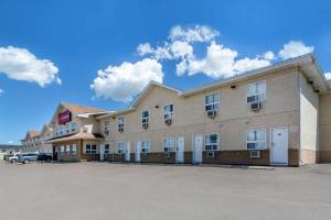 a large building with a car parked in a parking lot at Econo Lodge in Regina