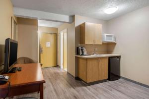 a small kitchen with a sink and a microwave at Econo Lodge in Regina