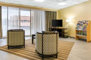 Habitación de hotel con 2 sillas y TV en Quality Inn & Suites, en Charleston