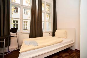 a small bed in a room with windows at Bearlin City Apartments - City Center East in Berlin