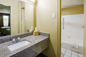 a bathroom with a sink and a mirror and a tub at Travel Inn Bristol near State Street in Bristol