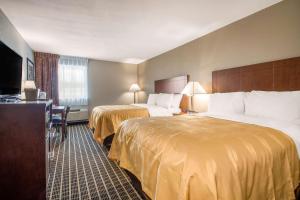 a hotel room with two beds and a flat screen tv at Quality Inn Madison West Near University Area in Madison