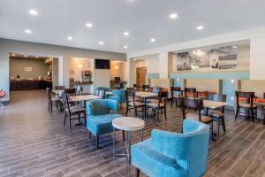 un restaurante con sillas azules, mesas y ools en Sleep Inn & Suites Ankeny - Des Moines, en Ankeny