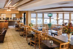 a restaurant with tables and chairs and windows at Quality Inn & Suites Downtown - University Area in Albuquerque