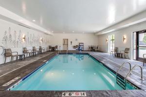 una piscina en una habitación con sillas y mesas en Sleep Inn & Suites Ankeny - Des Moines, en Ankeny