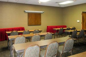 Quality Inn & Suites Albuquerque Downtown University في ألباكيركي: قاعة اجتماعات مع طاولات وكراسي ومنضدة