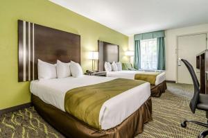 a hotel room with two beds and a desk at Quality Inn & Suites Creedmor - Butner in Creedmoor