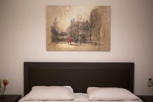 a painting hanging above a bed in a bedroom at Natural Beauty Spot in Áno Garoúna
