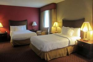 um quarto de hotel com duas camas e uma cadeira em Quality Inn & Suites Owego em Owego