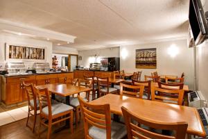 a restaurant with wooden tables and chairs and a kitchen at Quality Inn - Kitchener in Kitchener
